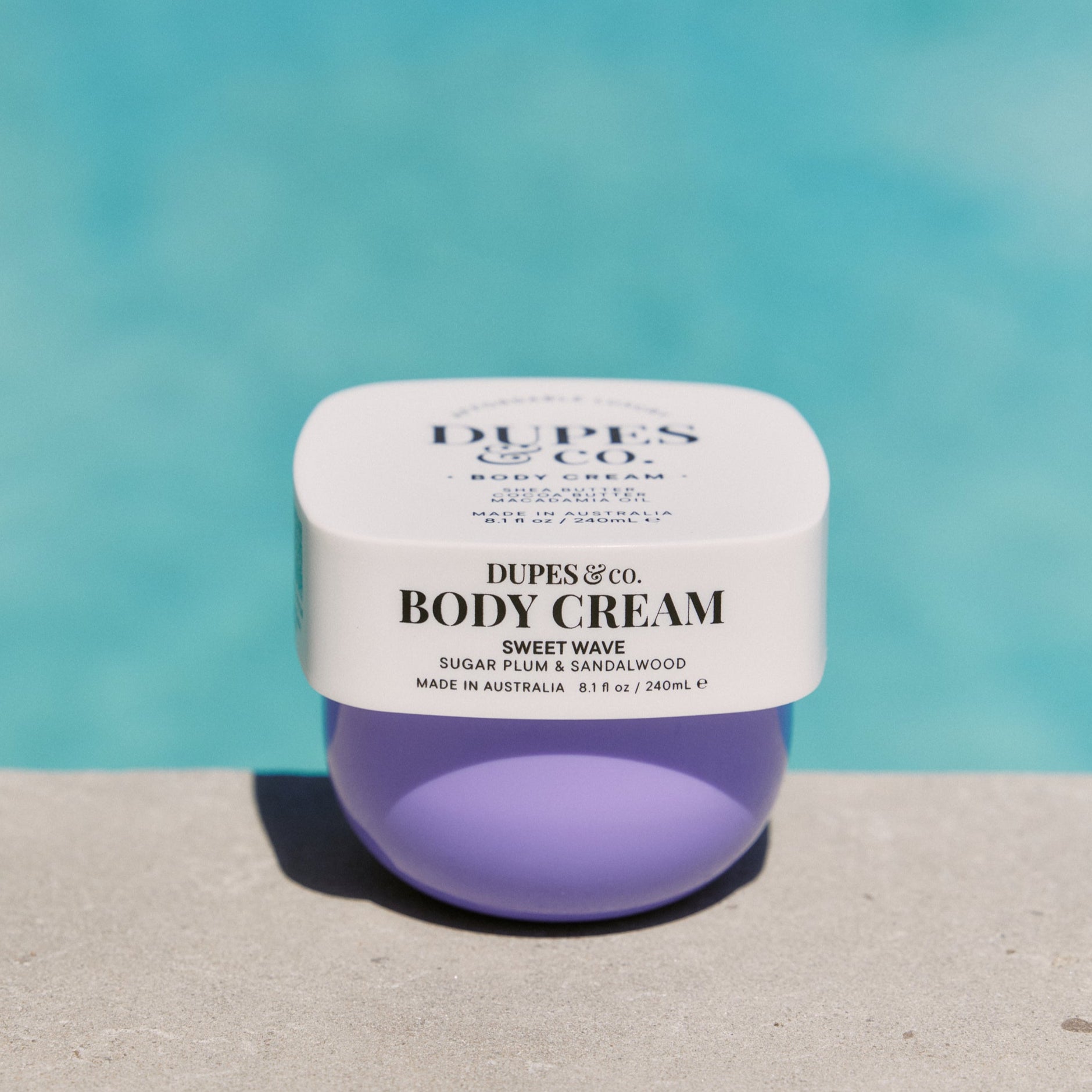 Jar of Dupes & Co. body cream with a blue background
